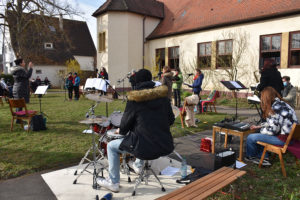 Der Jugendchor und die Flötengruppe von Shèron Waldner-Schöpf umrahmte den Gottesdienst - Choronakonform sang er in kleiner Besetzung auf der Wiese vor der Wolfbuschkirche. Foto: Uwe Tommasi